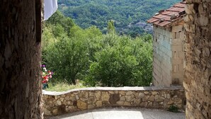 An arched stone doorway leading to a courtyard with a view of a mountain and greenery. - Cozy mini apartment on large terrace with unique view, pets allowed (Orturano)