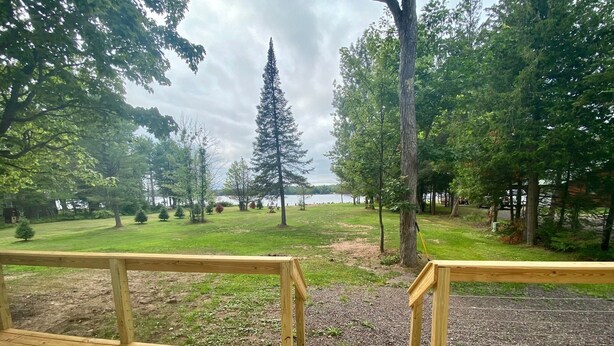 A wooden deck with a view of a park and a lake. - Lakeside Cottage Just Off Snowmobile/ATV Trail! (Lake Linden)