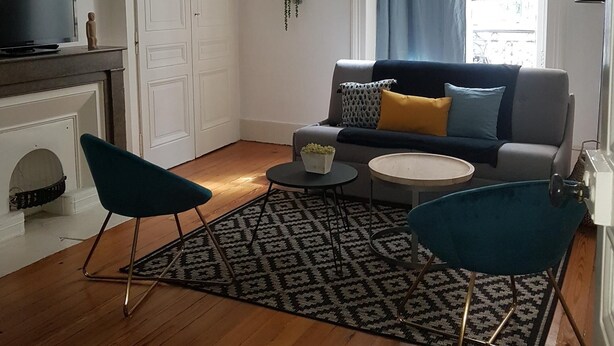 A living room with a sofa, two chairs, a coffee table, a TV, and a fireplace. - Saint Vincent convent (Lyon)