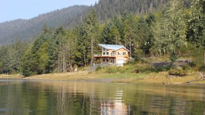 Una casa con un amplio balcón y un lago al frente.