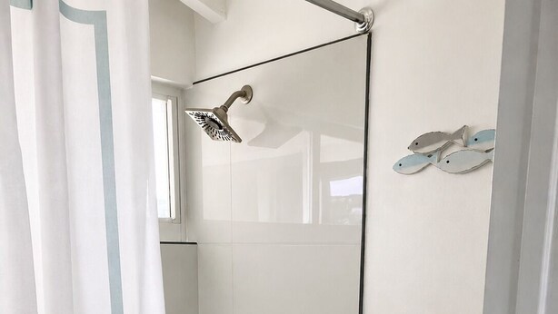 Een badkamer met een bad, toilet en douche.