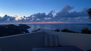 Blick vom Balkon auf ein Gewässer bei Sonnenuntergang.
