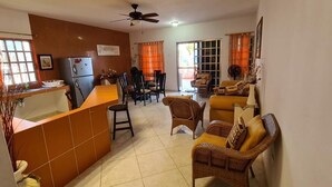 A spacious living area with a kitchen, dining table, and seating arrangements. - 114Night Sep/Oct Ocean Beach Front 2 Bedrooms Villa Cozumel Snorkel Scuba Diving (Cozumel)