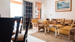A living room with a sofa, chairs, a coffee table, and a painting on the wall. - 114Night Sep/Oct Ocean Beach Front 2 Bedrooms Villa Cozumel Snorkel Scuba Diving (Cozumel)