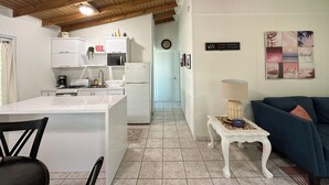 A modern kitchen with white cabinets, a white refrigerator, and a dining area with a white table and chairs. - Live Tropical like a local , El Yunque Rainforest View, Mountain View  (Río Grande)