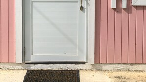 A white door with a security lock, a doormat, and a sign reading "BIENVENIDOS" on a pink building. - Live Tropical like a local , El Yunque Rainforest View, Mountain View  (Río Grande)