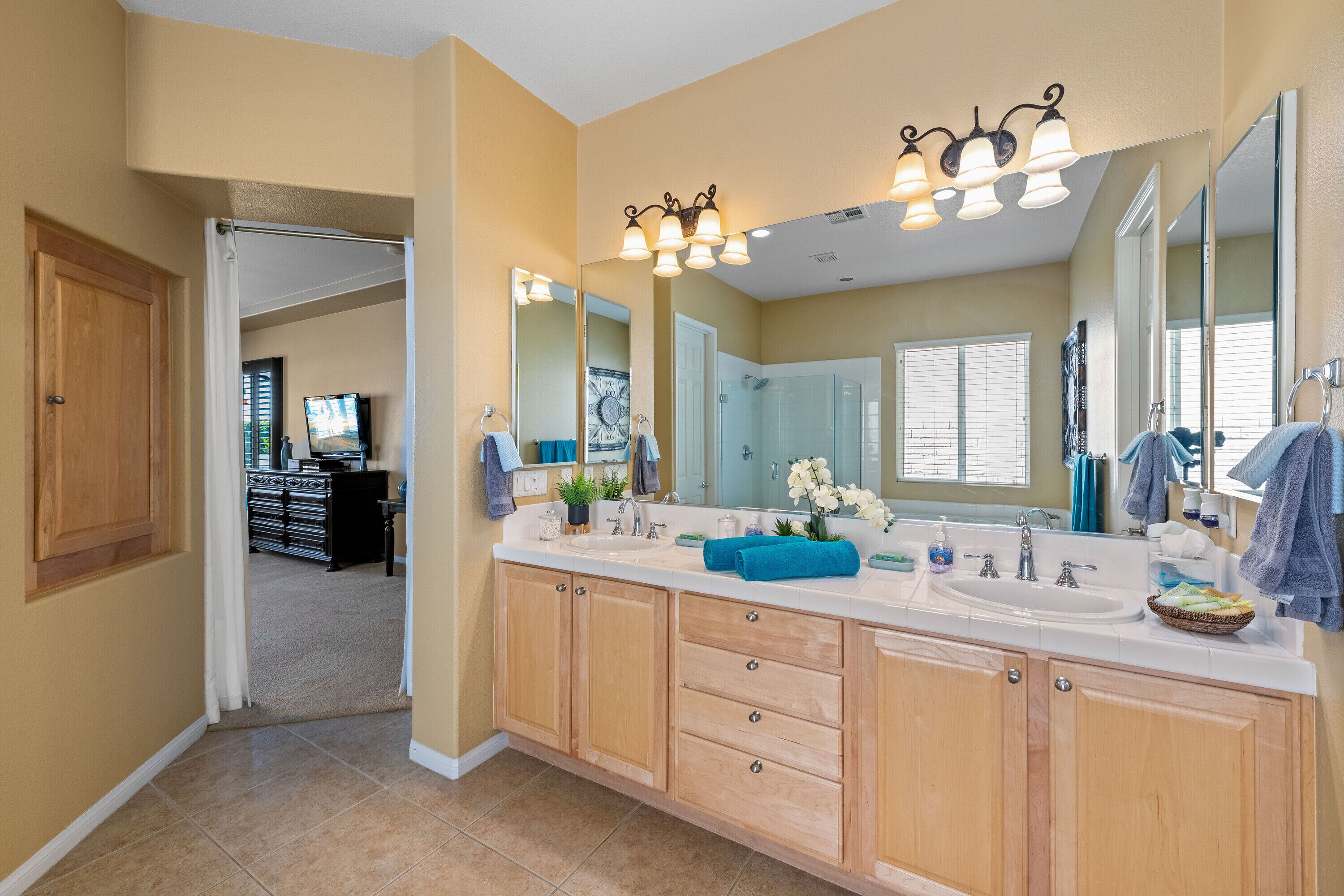 A spacious bathroom with a large vanity, double sinks, and a walk-in shower.