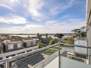 A residential area with a view of the sea, a clear sky, and a modern building with a glass balcony. - Slipway 15 (Wadebridge)
