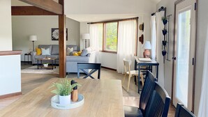Ett rymligt vardagsrum med ett matbord, en soffa och ett litet köksutrymme.