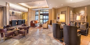 A modern lobby with leather seating, a reception desk, and a large window offering a view.