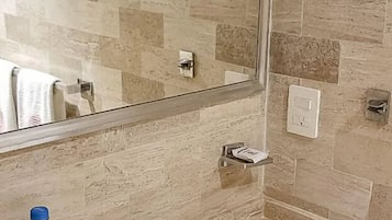 Un bagno con lavandino, specchio e pareti piastrellate.