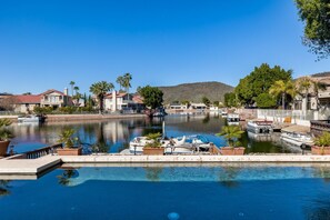 A marina with boats docked, surrounded by residential buildings and palm trees.