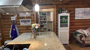 A kitchen with granite countertops, wooden cabinets, and a variety of kitchenware. - Lake living in a relaxed family and pet-friendly home (Chapin)