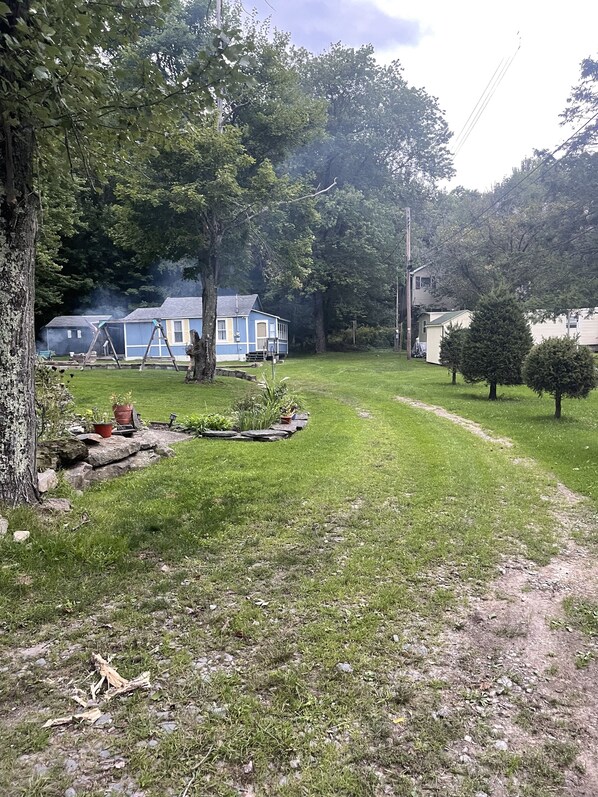 A residential area with a blue house, a swing set, and a lawn.