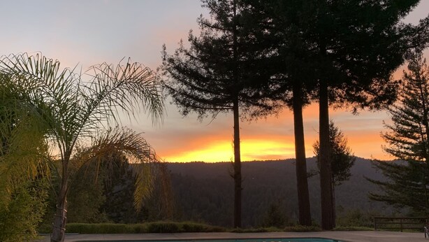 A swimming pool with a sunset view, surrounded by trees and a hilly landscape. - Escape To The Hacienda (Ben Lomond)