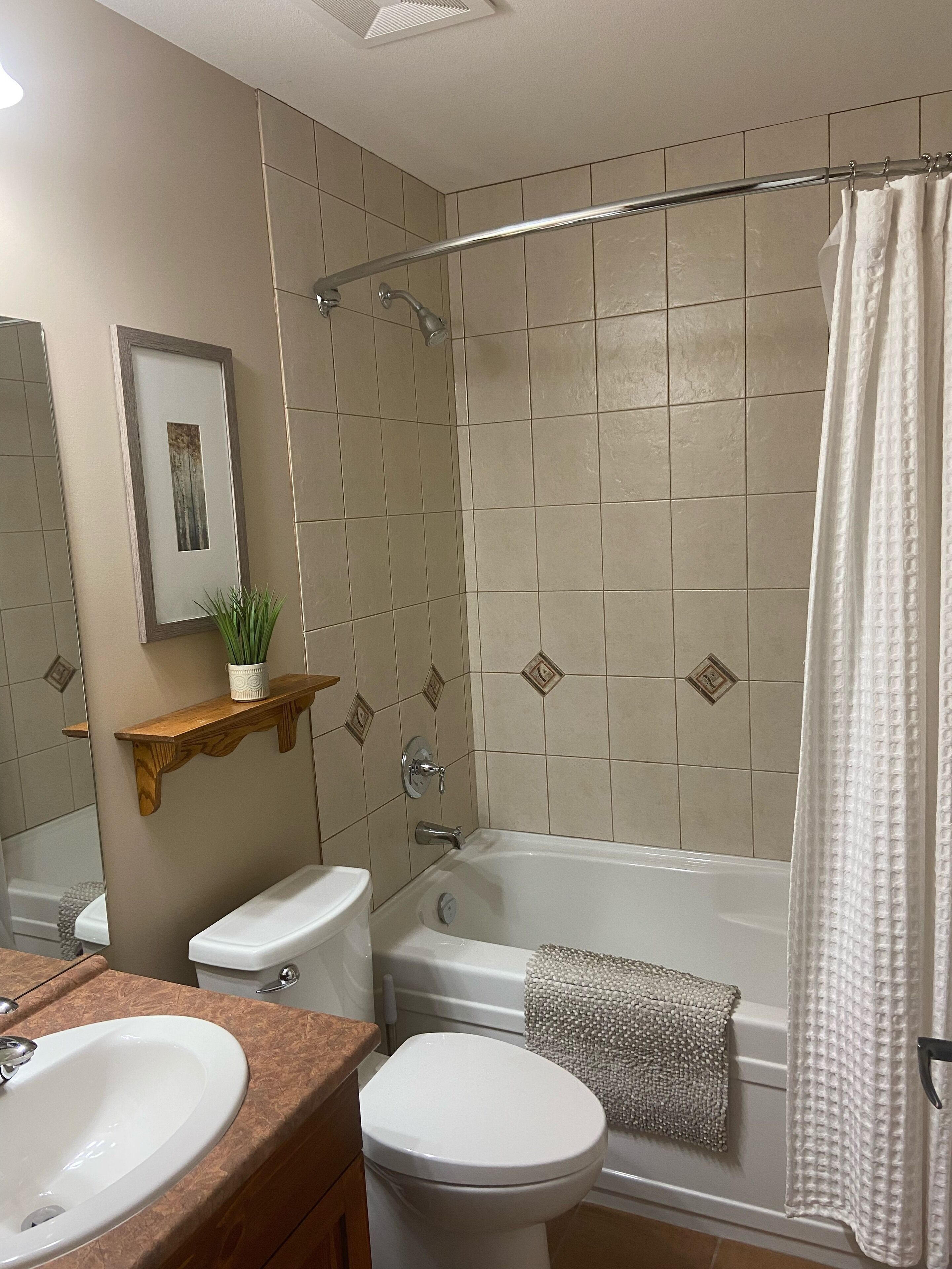 A bathroom with a bathtub, toilet, and sink.