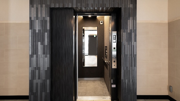An elevator with a modern design, featuring a patterned wall and a control panel on the right. - Tanimachikun Hotel Namba 80 (Osaka)