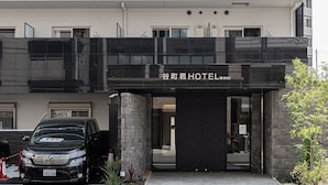 A hotel entrance with a modern design, featuring a glass canopy and stone pillars. - Tanimachikun Hotel Namba 80 (Osaka)