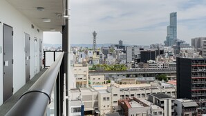 A cityscape with modern buildings, a prominent tower, and a view from a balcony. - Tanimachikun Hotel Namba 80 (Osaka)