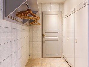 Un passadís amb una porta, parets de rajola i una barra penjant.