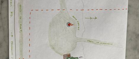 A hand-drawn map of a property with a house, a step drive, and a trail up a mountain.
