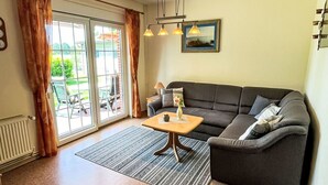 A living room with a sofa, a coffee table, a lamp, and a picture on the wall. - Osterkamp by Interhome (Westerholt)