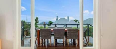 Una habitación con puerta de vidrio corredera que da a un patio exterior con una mesa y sillas de comedor.