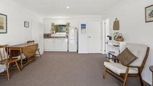 Un espacio habitable pequeño con una mesa de comedor, un sofá y una zona de cocina.