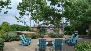 An outdoor seating area with Adirondack chairs and a fire pit.