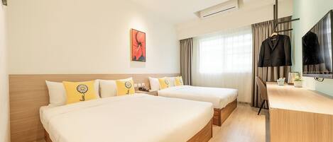 A hotel room with two beds, a desk, a TV, and a window with curtains.