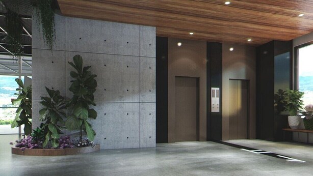 Un hall d’entrée moderne avec un mur en béton, un ascenseur et des plantes en pot.