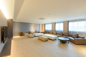 Amplia sala de estar con un sofá seccional grande, una mesa de centro y un televisor sobre un mueble de madera.