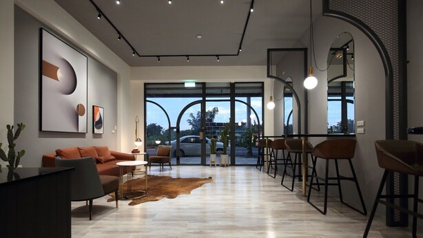 A modern interior with a reception desk, seating area, and large windows offering a view of the outdoors. - Light Year (Ji'an)