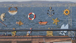 Une terrasse décorée sur le thème de la marine, avec notamment des motifs de dauphin, d’ancre et de bouée de sauvetage.
