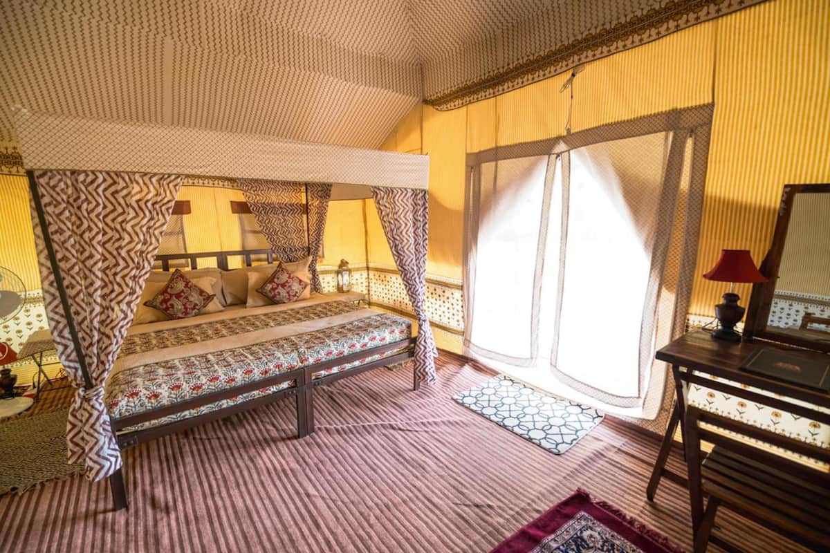 Ein Zimmer mit Bett, Schreibtisch und einem Vorhangfenster.