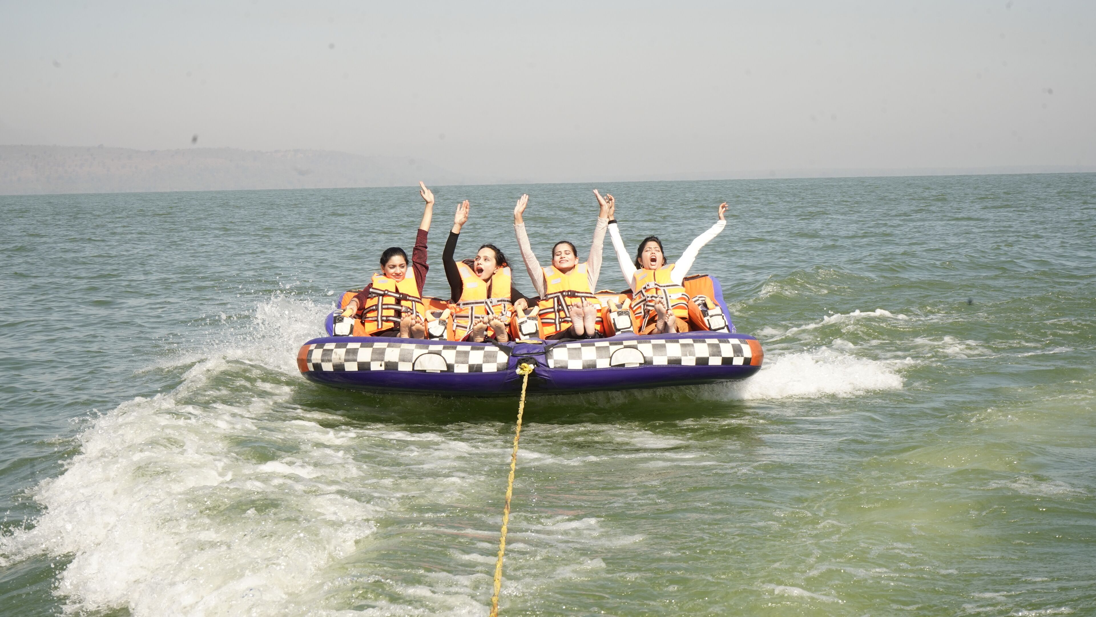 Un grupo de personas en una balsa inflable a cuadros sobre aguas abiertas.