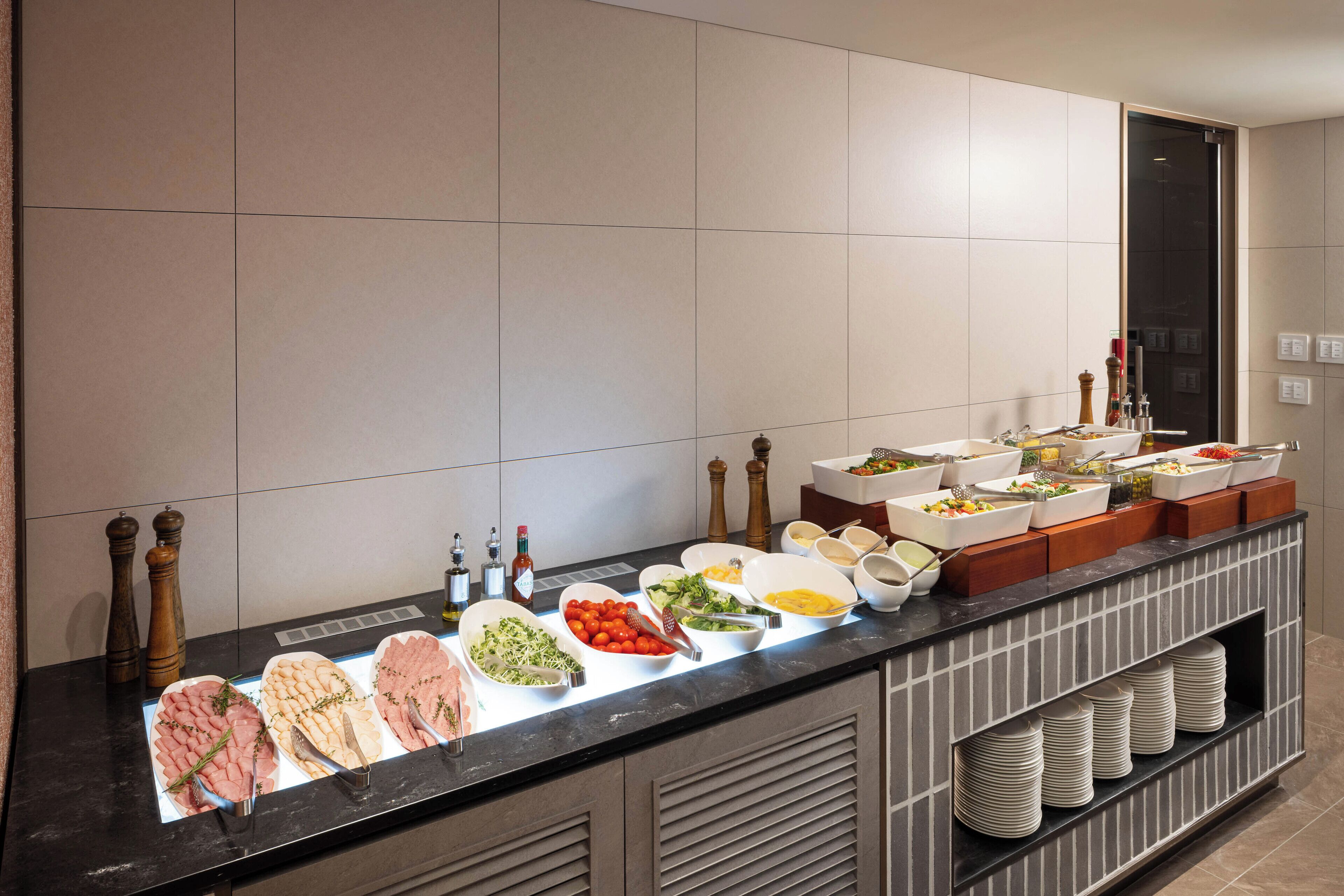 A buffet setup with various food items and condiments.
