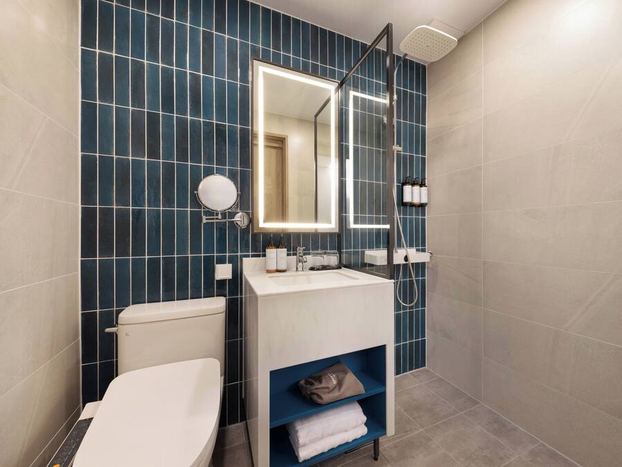 Un baño moderno con inodoro, lavamanos y ducha.