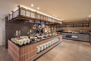 Ein reichhaltiges Buffet mit verschiedenen Speisen und einer Kaffeestation.