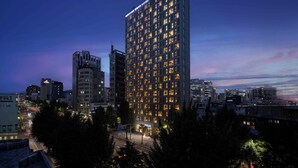 A high-rise hotel with multiple floors, illuminated windows, and a modern architectural design.