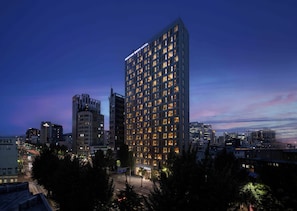 A high-rise hotel with multiple floors, illuminated windows, and a modern architectural design. - Mercure Ambassador Seoul Dongdaemun (Seoul)