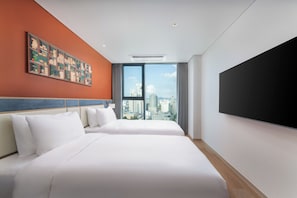 A hotel room with two beds, a large window with a city view, a mounted TV, and a colorful artwork on the wall. - Mercure Ambassador Seoul Dongdaemun (Seoul)