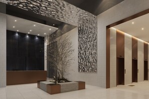 A modern lobby with a central planter, recessed lighting, and a patterned wall. - Mercure Ambassador Seoul Dongdaemun (Seoul)