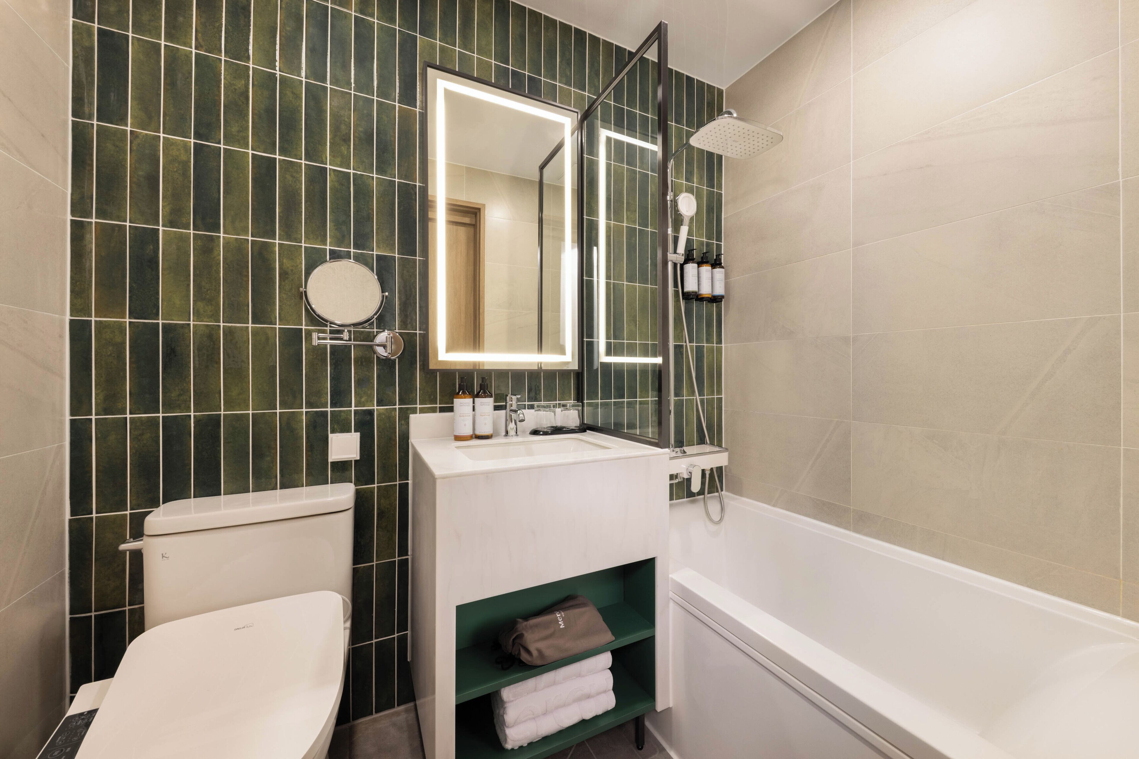 Une salle de bain équipée de toilettes, d’un lavabo, d’un miroir et d’une douche.