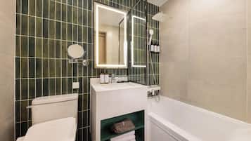 Un baño con inodoro, lavabo, espejo y ducha.