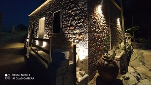 Un bâtiment en pierre avec une porte en bois et une plante en pot.