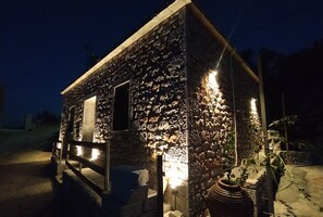 Un bâtiment en pierre avec une porte en bois et une plante en pot.