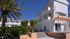A multi-story building with balconies, a sign reading 'Apartamentos Maracá', and a palm tree in the foreground. - Apartment Hotel Maracaibo Standard with Pool, Wi-Fi & Terrace (Can Picafort)