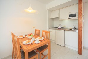 A compact kitchen with white cabinets, a microwave, and a dishwasher.
