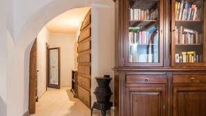 Un couloir avec un meuble en bois, un poêle et une bibliothèque.